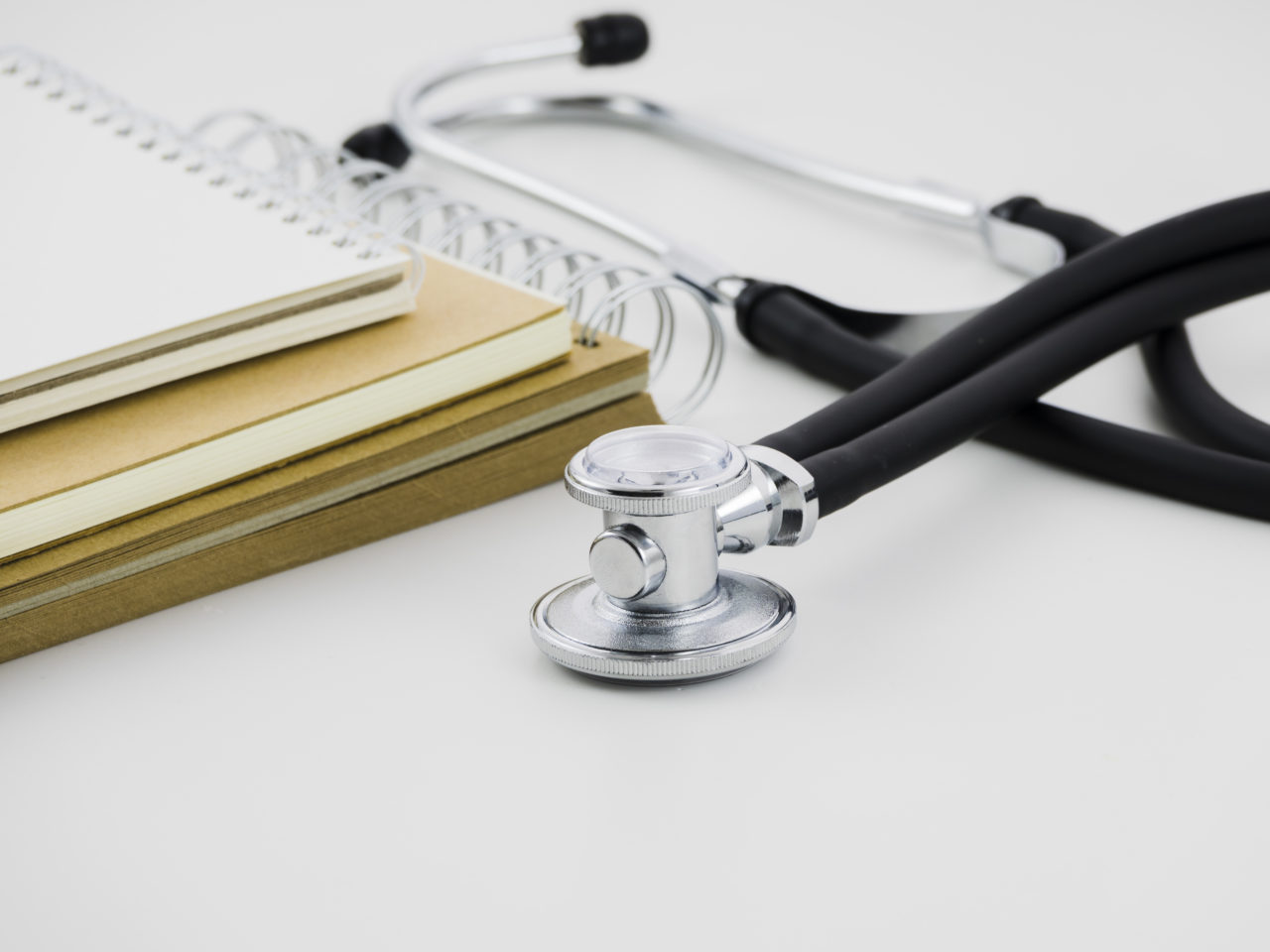 https://global-advice.ch/wp-content/uploads/2024/07/stack-spiral-notepad-stethoscope-white-backdrop-1280x960.jpg